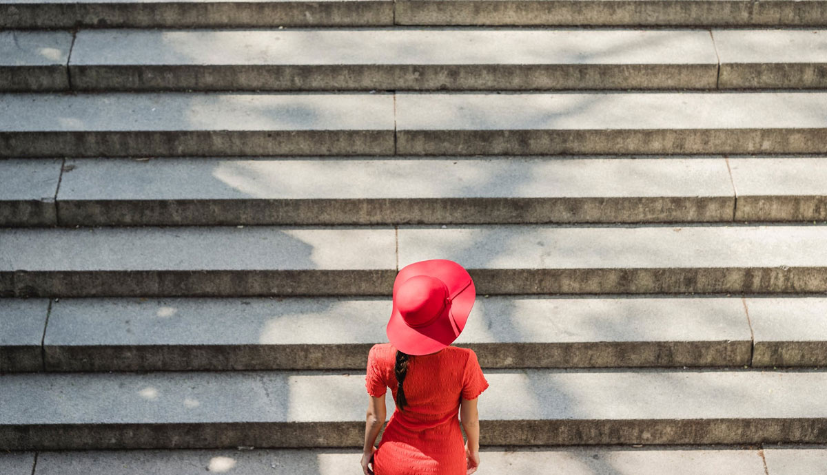 a woman in red dress climbing intimidating stairs